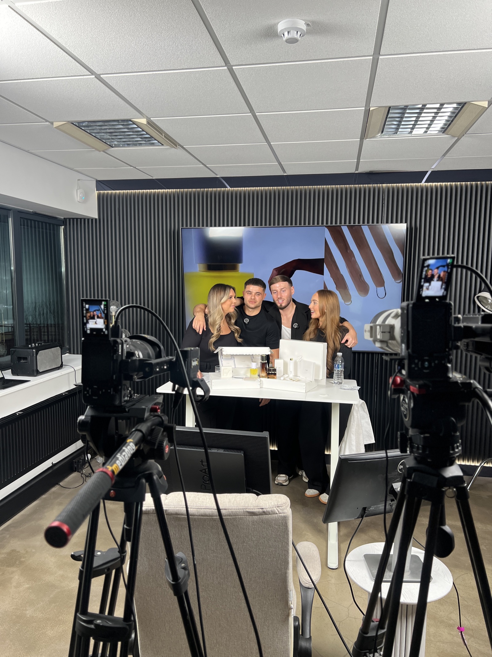 Hosts mid-broadcast at the desk on a Somerce daily LIVE set